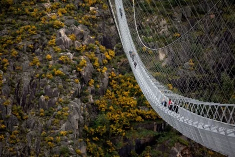Pessoas corajosas atravessam a maior ponte suspensa para pedestres do mundo (CRÉDITO: VIOLETA SANTOS MOURA/REUTERS)