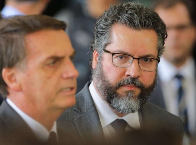 Presidente Jair Bolsonaro e Ernesto Araújo (ao fundo) (CRÉDITO: SÉRGIO LIMA/PODER360)